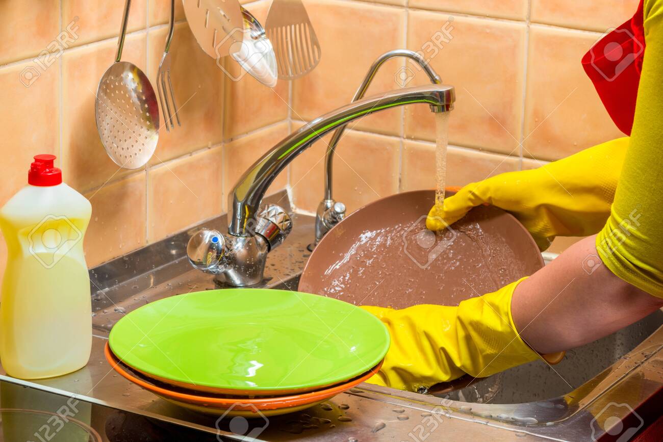 118898478 homework washing dishes close up hands with plates in gloves 1