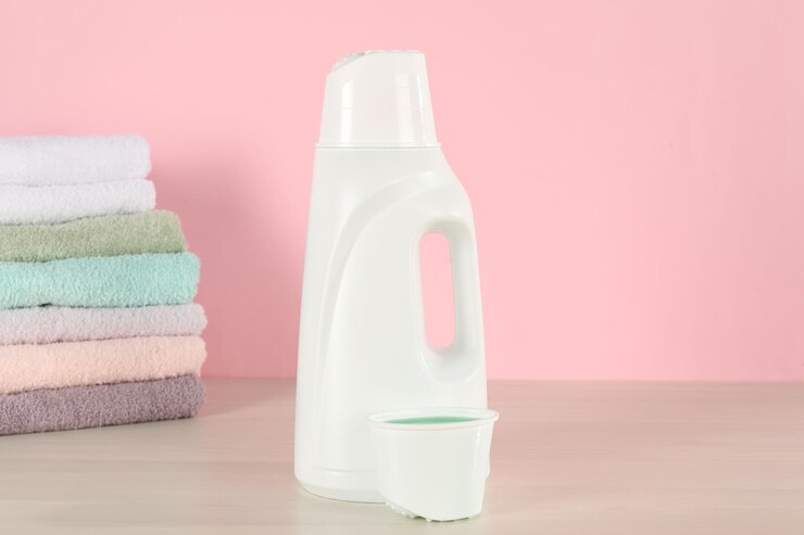 خرید مایع لباسشویی به صرفه با قدرت لکه زدایی بالا 2 bottle with laundry detergent cap stack clean towels wooden table against pink background 495423 117704