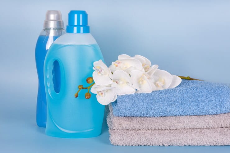 bottles detergent fabric softener with clean towels orchid flowers blue background 99272 3299 1