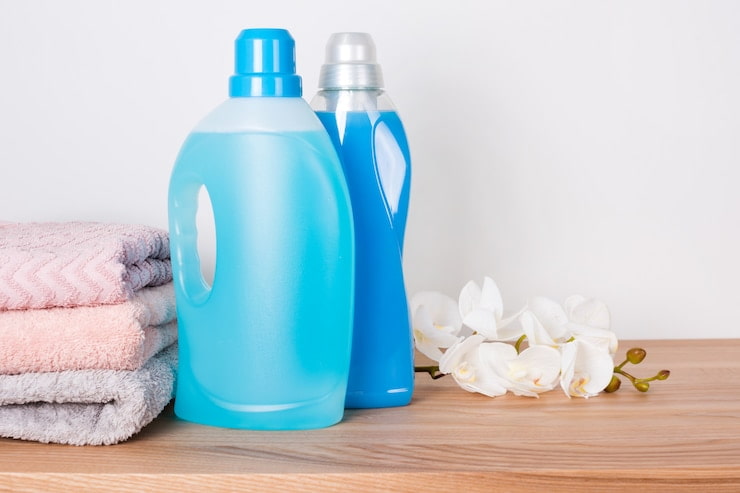 bottles detergent fabric softener with clean towels orchid flowers wooden table 99272 3296 1