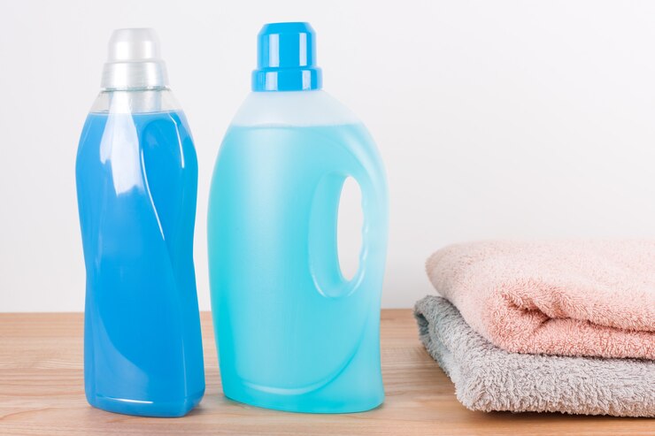 bottles detergent fabric softener with clean towels wooden table 99272 3293 1 1