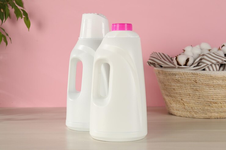 bottles with laundry detergent clothes basket wooden table against pink background 495423 115510