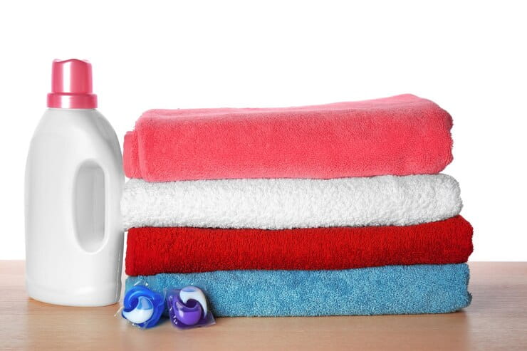 فروش عمده مایع لباسشویی عطری سازگار و خوشبو 3 folded towels laundry detergent table against white background 392895 468913 1