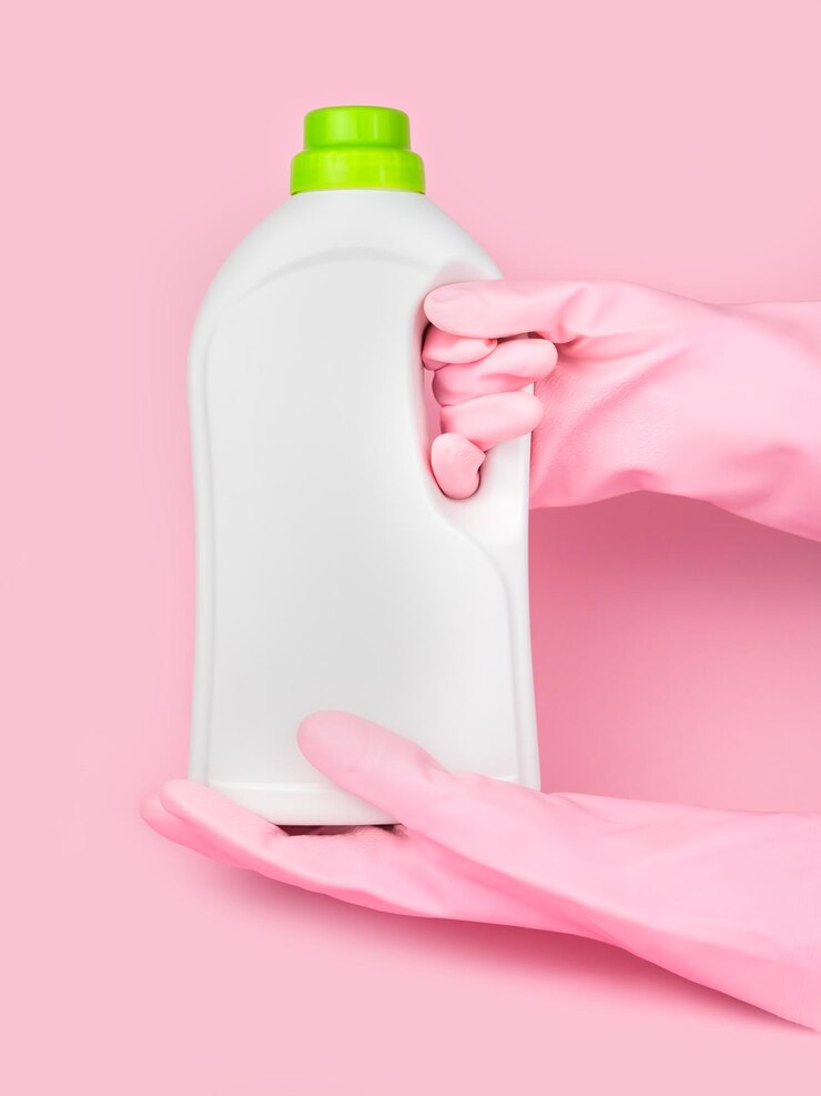 hands pink rubber gloves holds bottle laundry conditioner pink background mockup closeup selective focus 353415 248