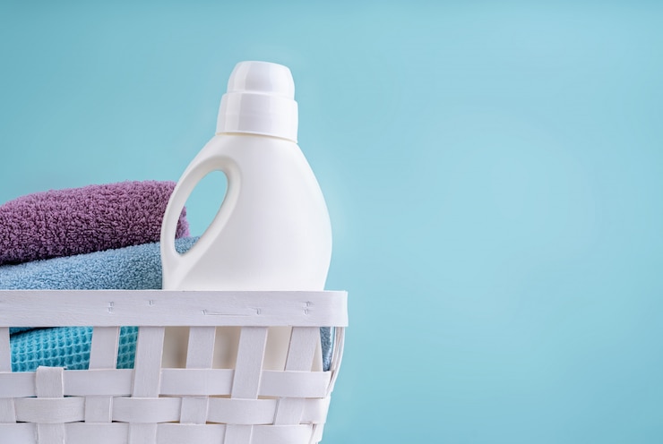 laundry basket with detergent bottle pile clean towels white table isolated blue background 154515 121 1