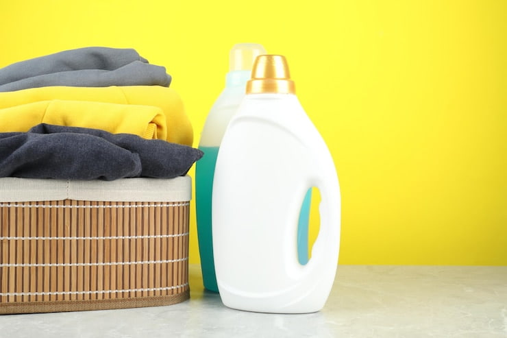 laundry detergent bottles clothes grey marble table against yellow background space text 495423 112493 1 1