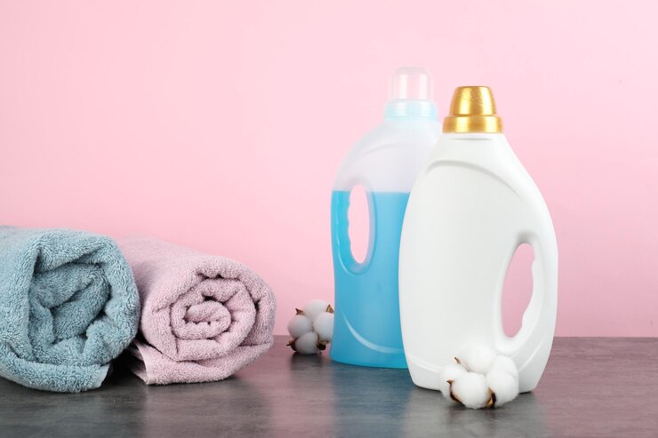 laundry-detergent-bottles-cotton-flowers-towels-grey-table_495423-114896