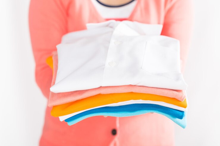 midsection woman holding folded shirts against white background 1048944 24916484