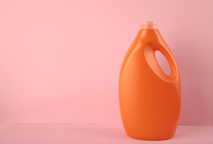 orange plastic bottle with liquid laundry detergent cleaning agent bleach fabric softener pink background 106006 11426
