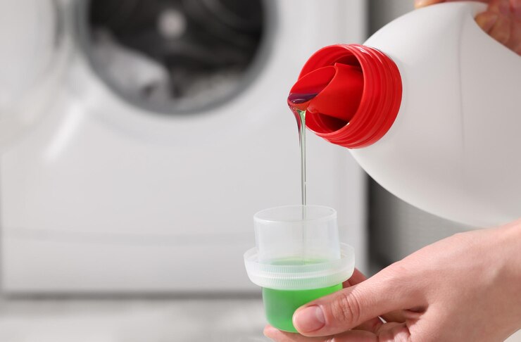 woman pouring fabric softener from bottle into cap washing clothes indoors closeup space text 1339860 3950 1